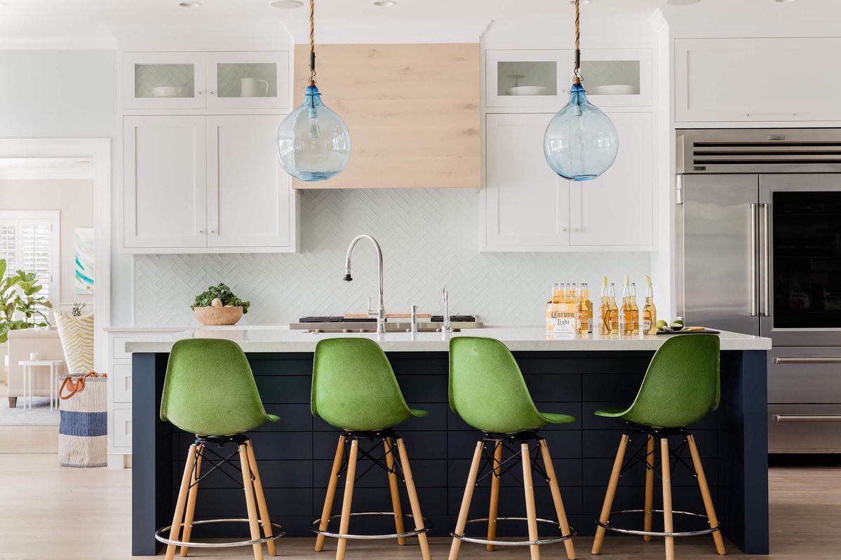 White coastal kitchen with green counter stools