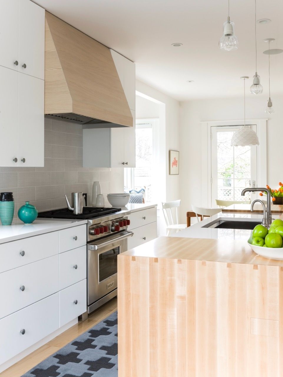 Natural wood hood and island in white Scandinavian kitchen