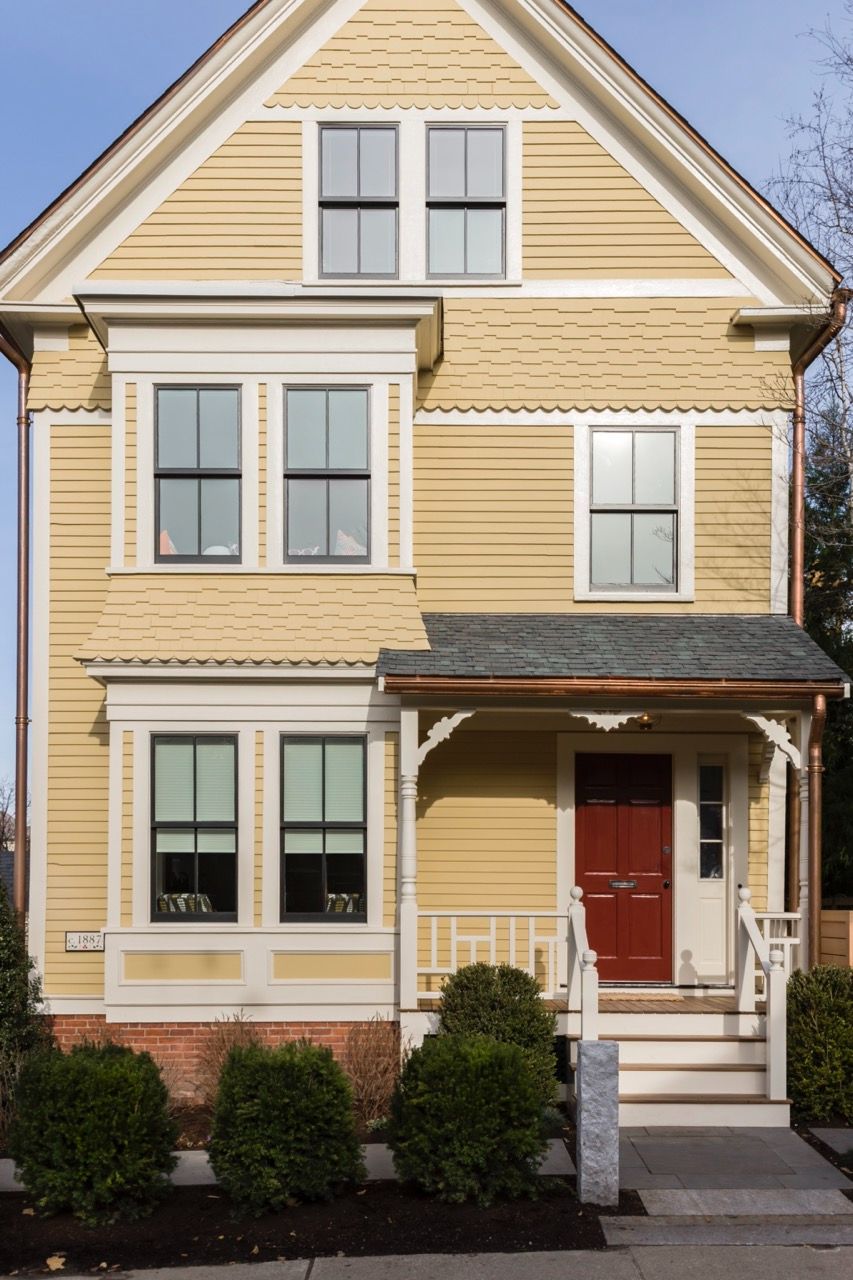 Yellow and white Scandinavian house with red door