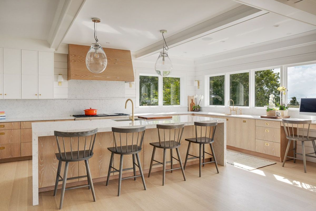 Coastal kitchen painted white with oak cabinets and floors