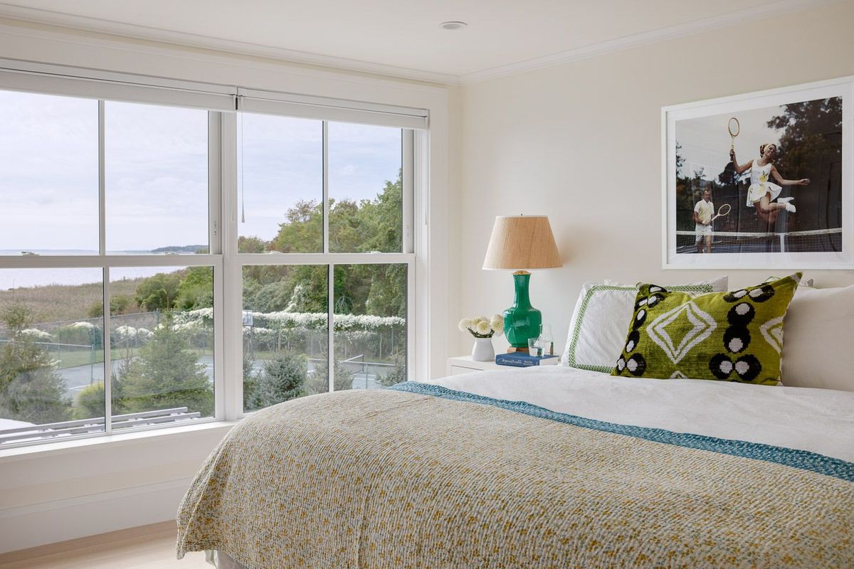 Guest room with green accents overlooking tennis court