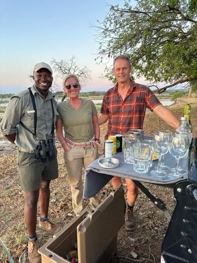 Guide and couple with refreshments while on Safari