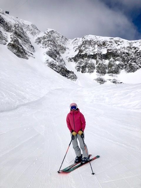 Skiier in pink jacket in Big Sky mountains