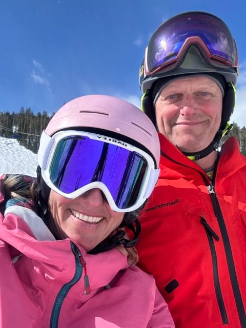 Two skiiers smiling on mountain