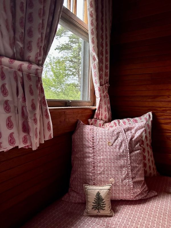 Window seat with pink patterned textiles